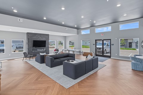 A spacious living room with a grey sofa set and a television.