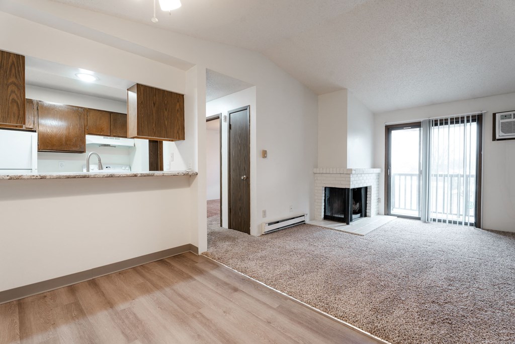 A living room with a fireplace and sliding glass doors. at Bristol Ridge, Urbandale, 50322