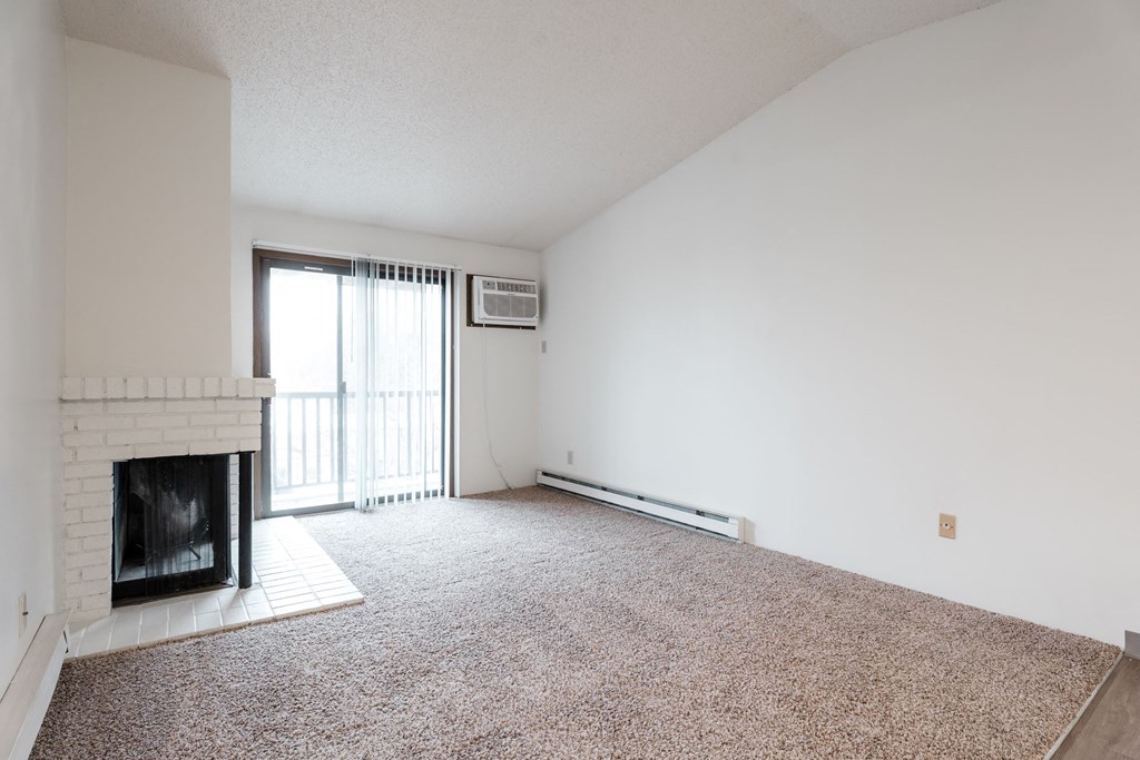 A room with a fireplace and carpeted floor. at Bristol Ridge, Urbandale, IA, 50322
