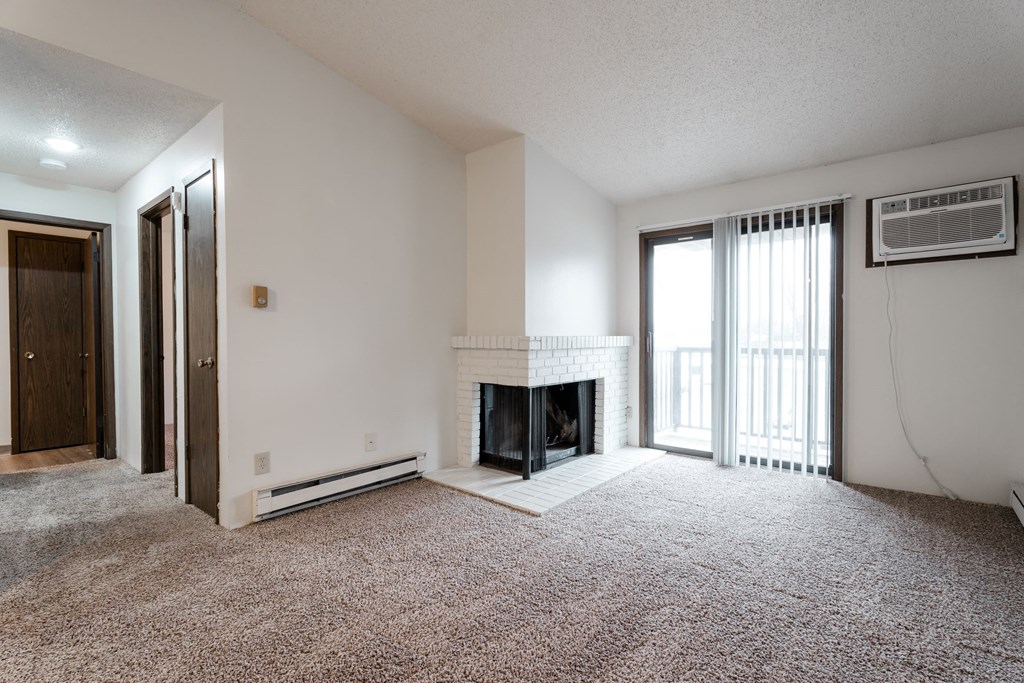 A living room with a fireplace and a carpet. at Bristol Ridge, Urbandale, IA