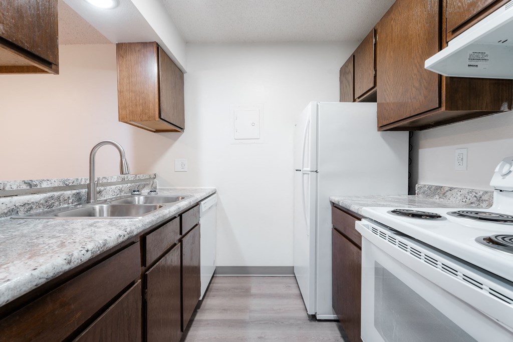 A kitchen with a white refrigerator and a white stove top oven. at Bristol Ridge, Urbandale, IA