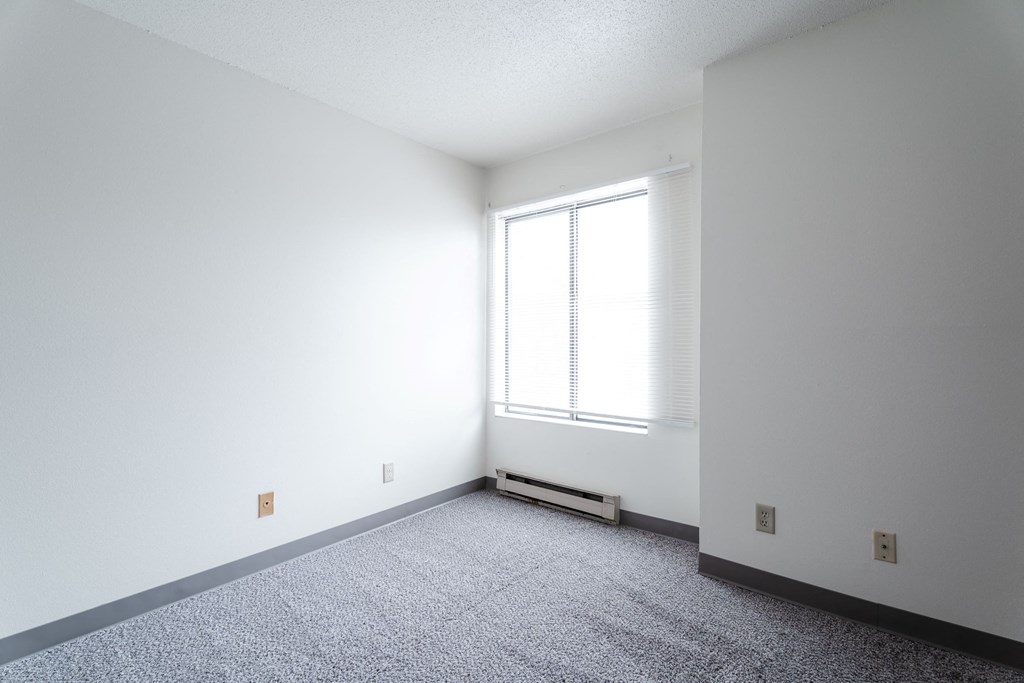 A room with a window and a radiator on the floor. at Bristol Ridge, Urbandale, Iowa