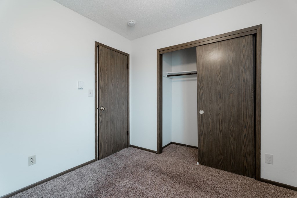 A room with two doors and a carpeted floor. at Bristol Ridge, Urbandale, IA, 50322