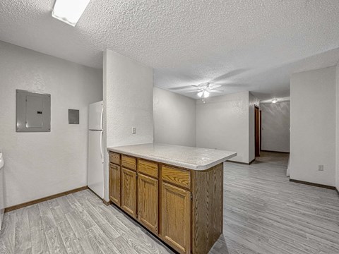 A kitchen area with wooden cabinets and a white countertop.