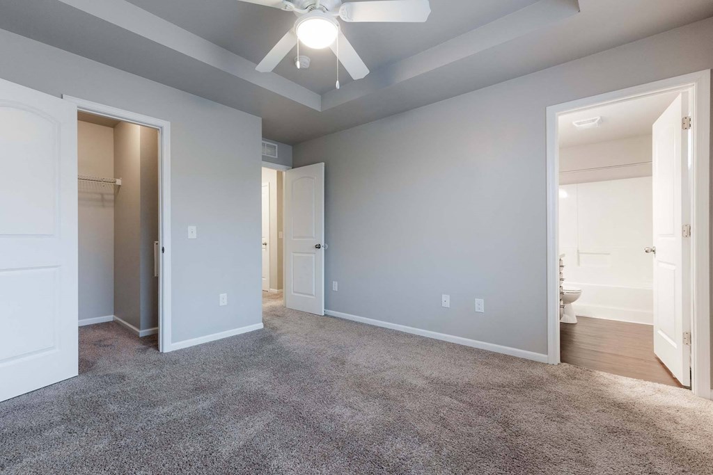 A room with a ceiling fan and carpeted floor. at Danamere Village, Carlisle, 50047