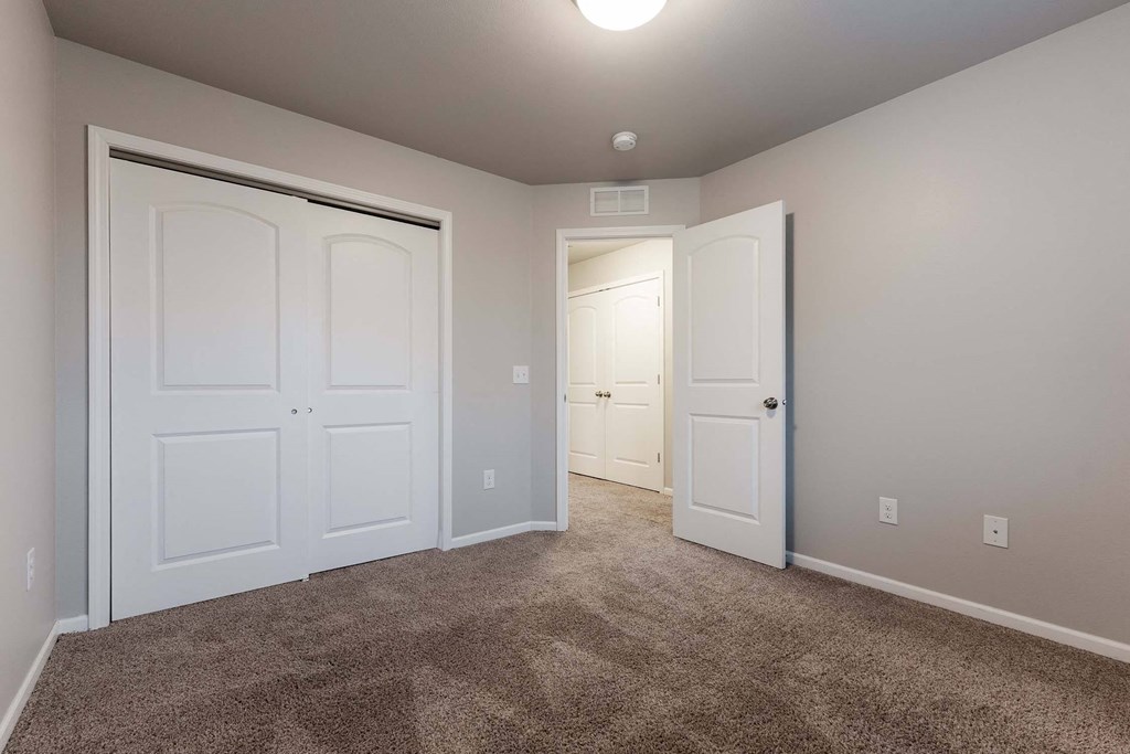 A room with two white doors and carpeted floor. at Danamere Village, Iowa, 50047