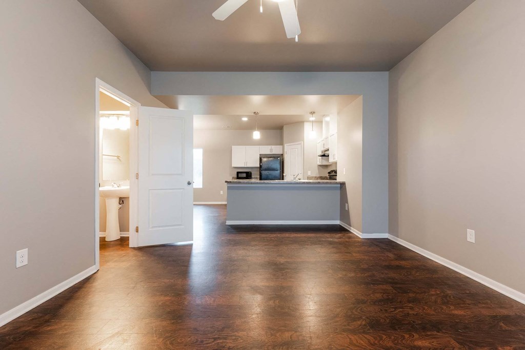 A spacious kitchen and living room with hardwood floors and a ceiling fan. at Danamere Village, Carlisle, 50047