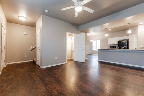 A spacious room with a ceiling fan and wooden flooring.