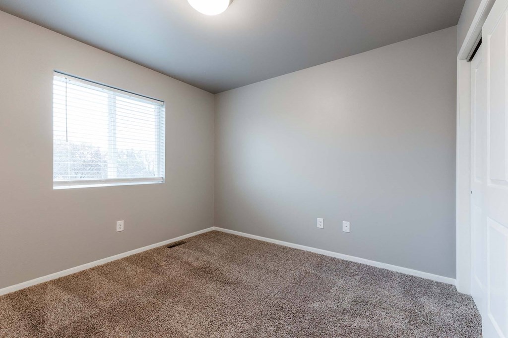 A room with a carpeted floor and a window with blinds. at Danamere Village, Carlisle