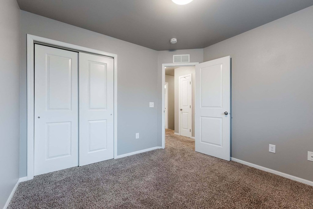 A room with white doors and carpeted floor. at Danamere Village, Carlisle, 50047