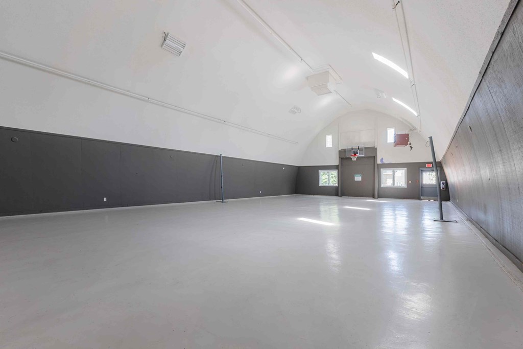 A long, empty hallway with a white ceiling and walls.
