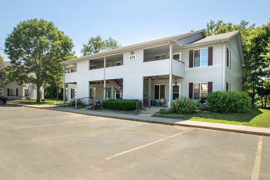 A white two-story building with a parking lot in front. A white two-story building with a parking lot in front at Hunters Run Apartments, Newton
