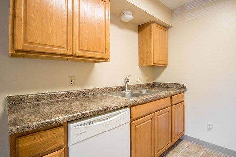 A kitchen with wooden cabinets and a granite countertop.