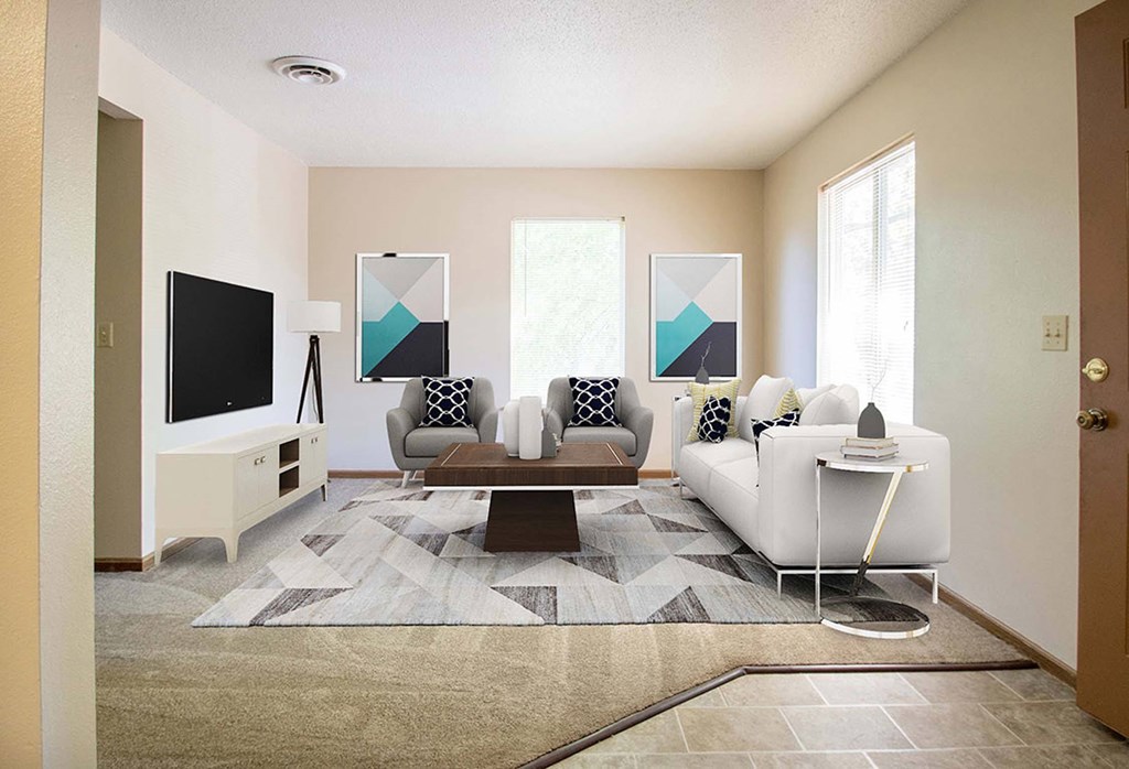 A living room with a white couch, a coffee table, and a television. A living room with a white couch, a coffee table, and a television at Hunters Run Apartments, IA, 50208