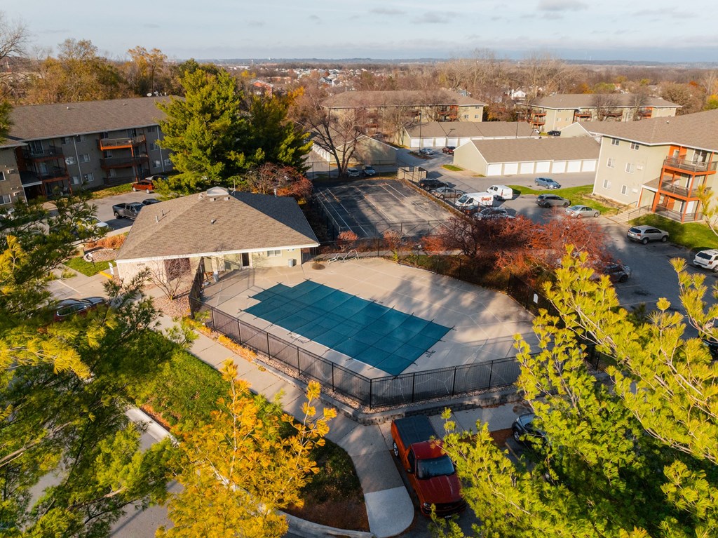 A red truck is parked by a pool in a residential area. at Rosemont Place Apartments, Iowa, 50320