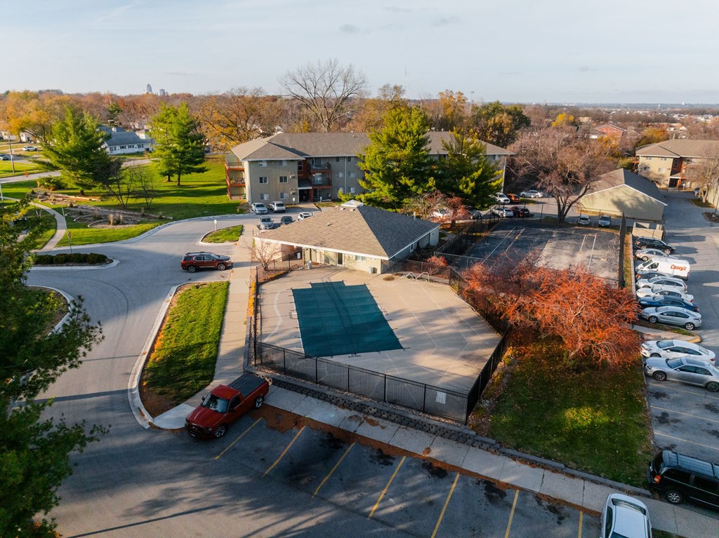 A parking lot with a red car and a building in the background at Rosemont Place Apartments, Iowa, 50320