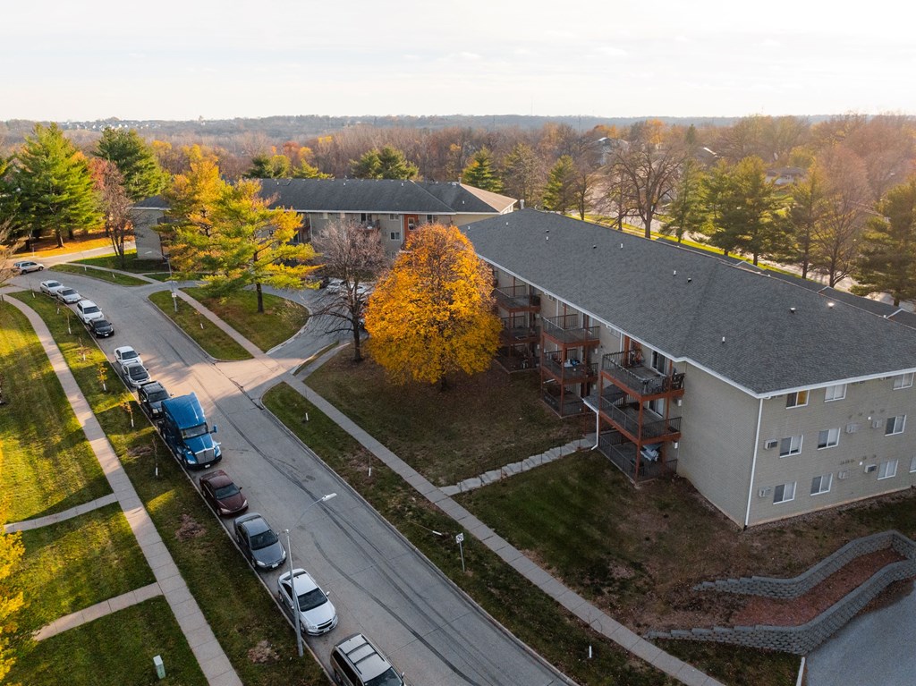 A parking lot with cars and a building in the background at Rosemont Place Apartments, Des Moines, Iowa