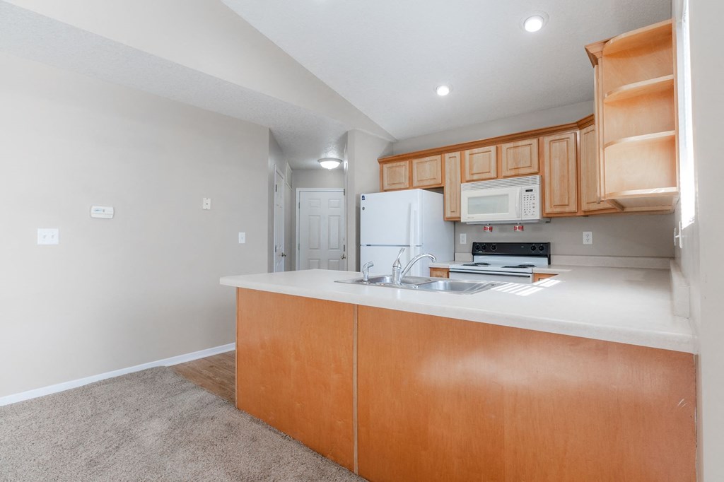A kitchen with a white counter top and wooden cabinets. at Saylorville Lakeside, Polk City, IA