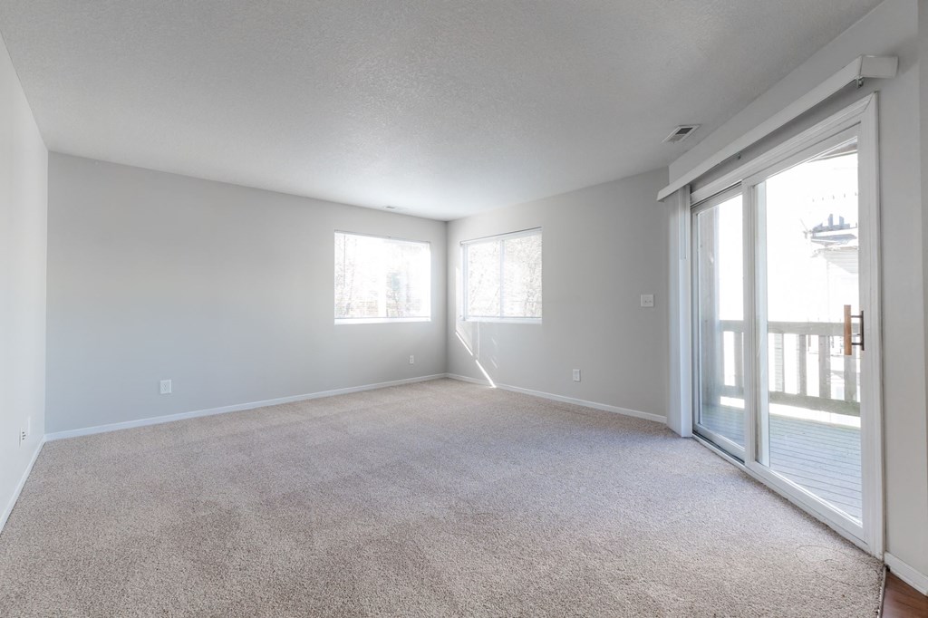 A spacious room with carpeted floor and sliding glass doors. at Saylorville Lakeside, Polk City, IA, 50226