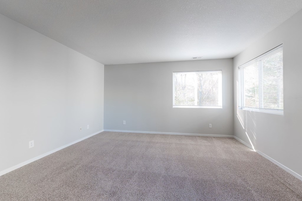 A spacious room with carpeted floor and two windows. at Saylorville Lakeside, Polk City, Iowa
