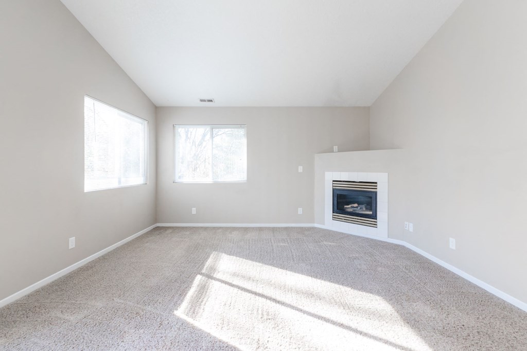A sunny room with a fireplace and carpet. at Saylorville Lakeside, Iowa