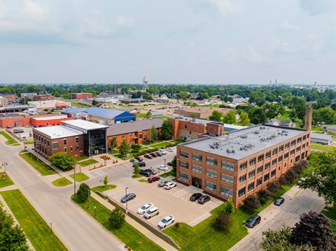 A large building complex with a parking lot in front at Spaulding Lofts Apartments, Grinnell, IA