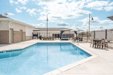 A large swimming pool with a white fence surrounding it.
