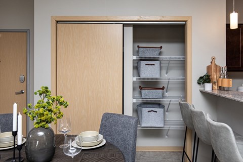 a dining room with a table and chairs and an open refrigerator at Lake Shore Apartments, Ankeny, 50021