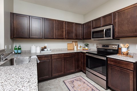 A kitchen with brown cabinets and a granite countertop.