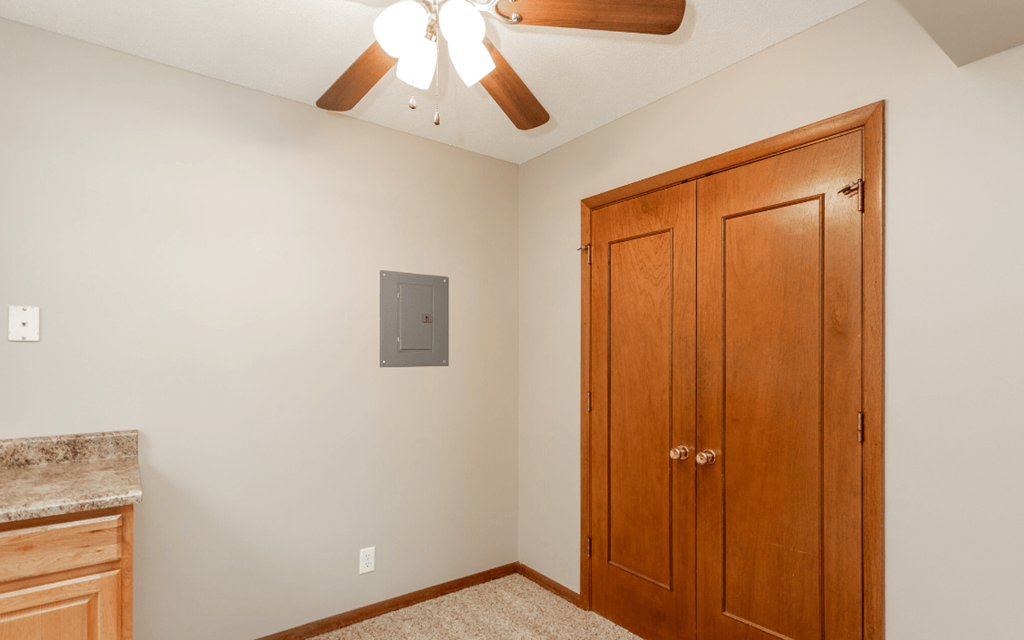 an empty bedroom with a closet and a ceiling fan at Lake Shore Place Apartments, Iowa