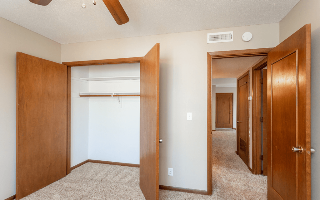 the view of a bedroom with a closet and a mirrored closet door at Lake Shore Place Apartments, Ankeny, IA,  50021