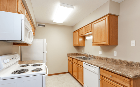 A kitchen with a white stove and a white dishwasher.