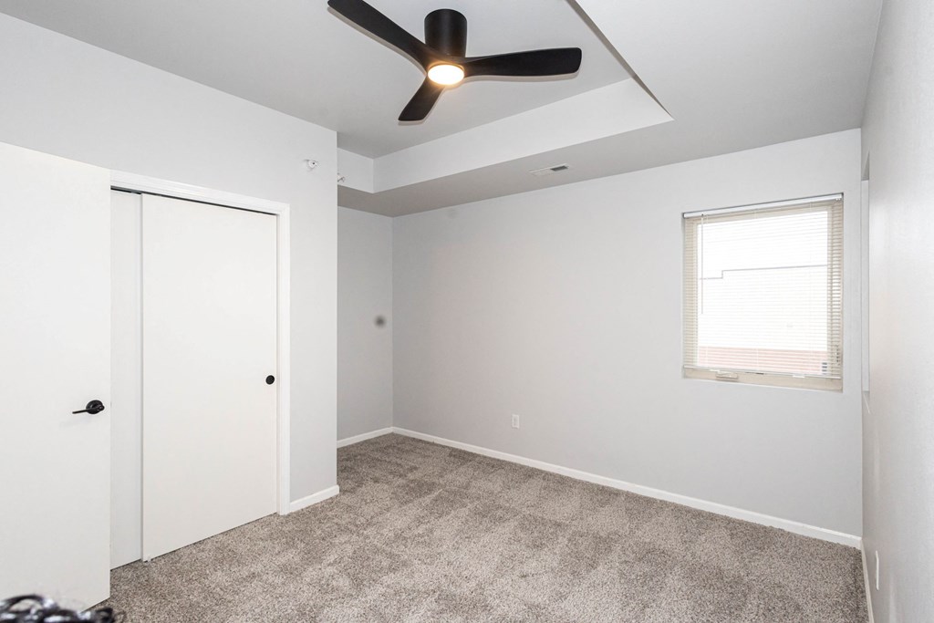 A room with a ceiling fan and a window with blinds at Meadowlark Place Apartments, IA, 50111