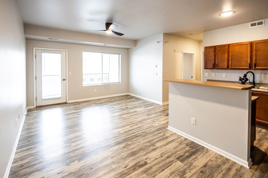 A room with a kitchen area and a ceiling fan at Meadowlark Place Apartments, Iowa, 50111