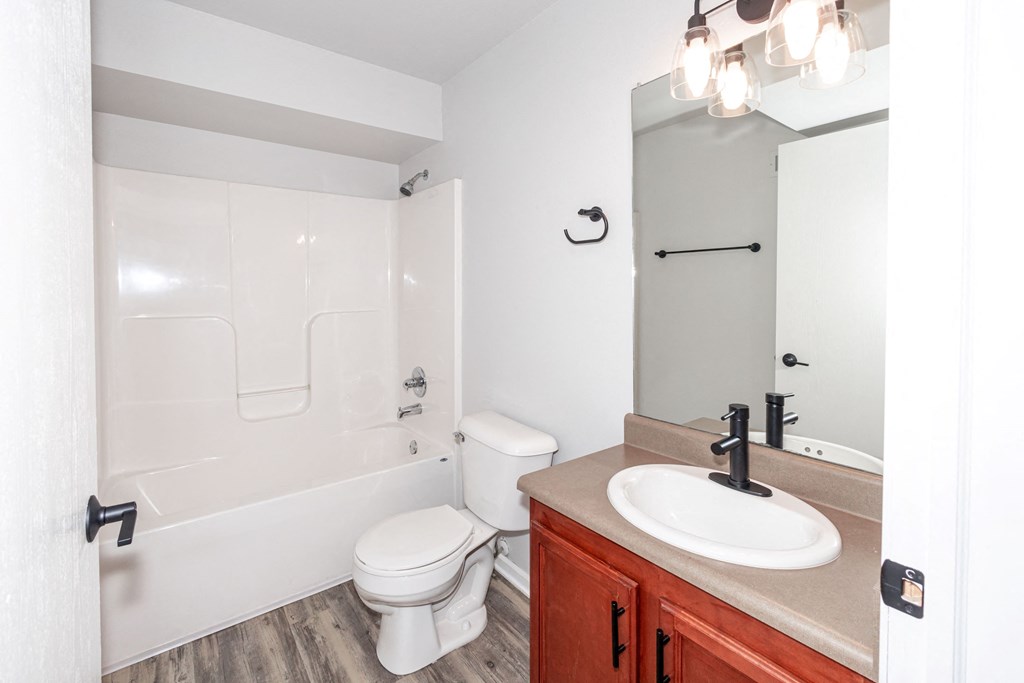 A white toilet sits next to a sink in a bathroom at Meadowlark Place Apartments, Iowa, 50111