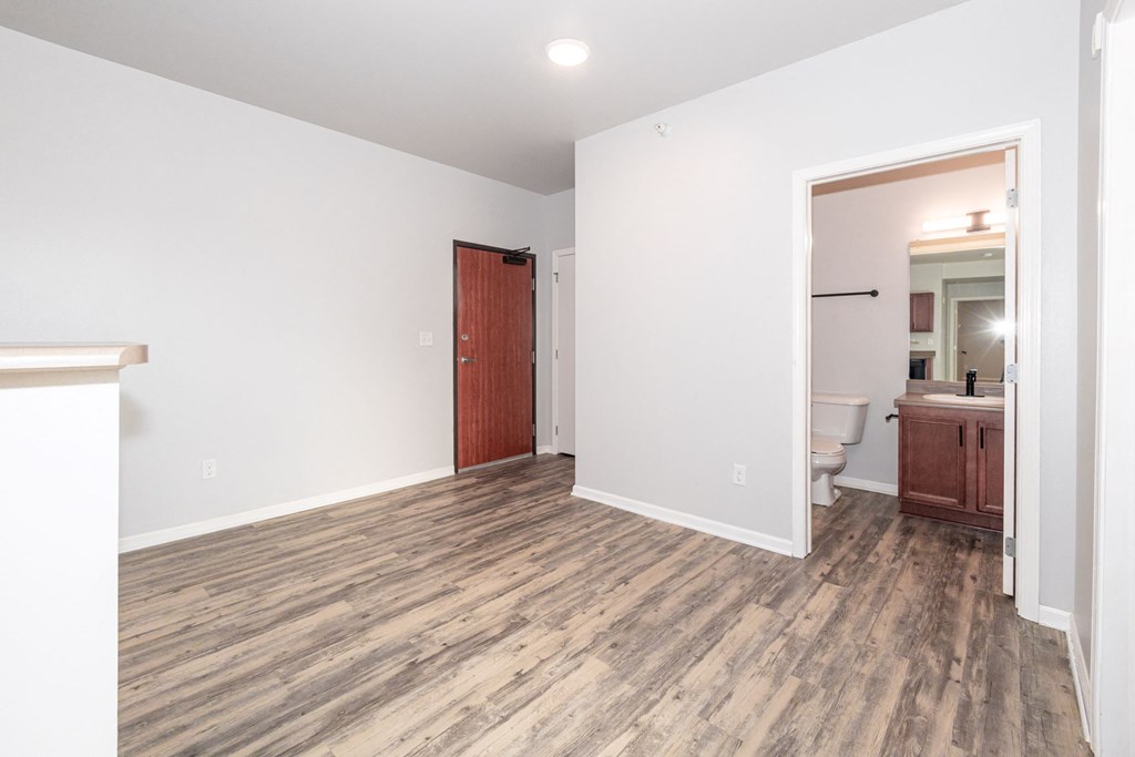 A room with a wooden floor and a red door at Meadowlark Place Apartments, IA, 50111
