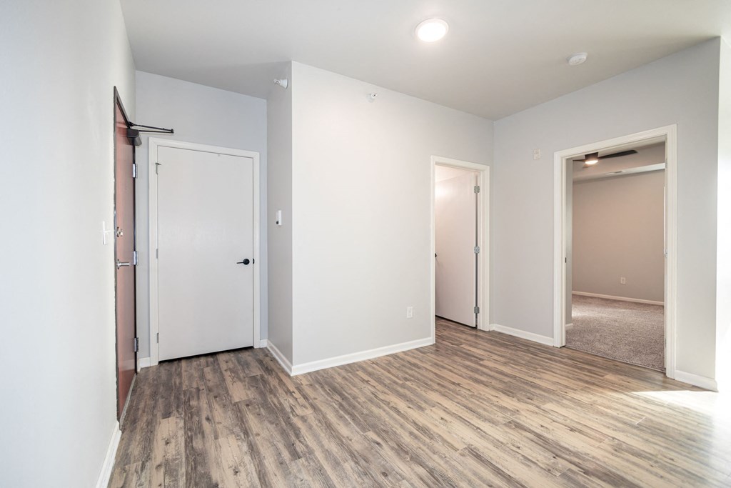 A room with a white door and a brown floor at Meadowlark Place Apartments, Georgia