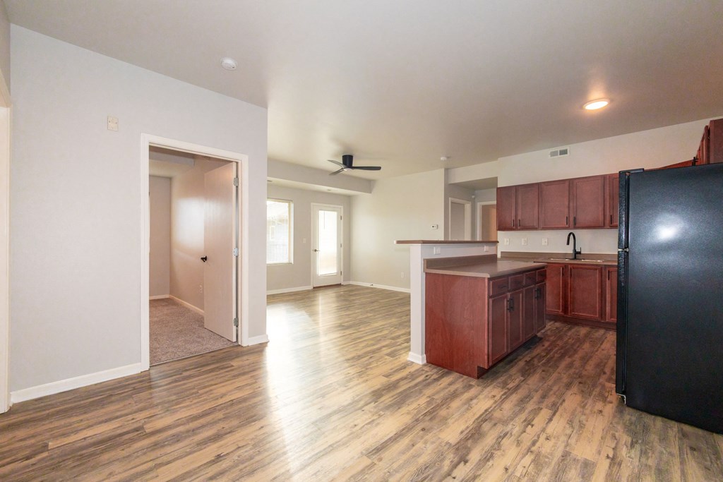 A kitchen with wooden floors and a black refrigerator at Meadowlark Place Apartments, Iowa, 50111
