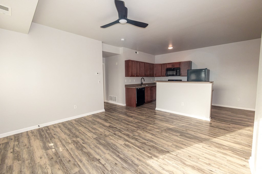A room with a ceiling fan and wooden flooring at Meadowlark Place Apartments, Grimes