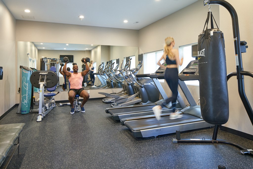 A man and a woman are working out in a gym at Meadowlark Place Apartments, Iowa, 50111