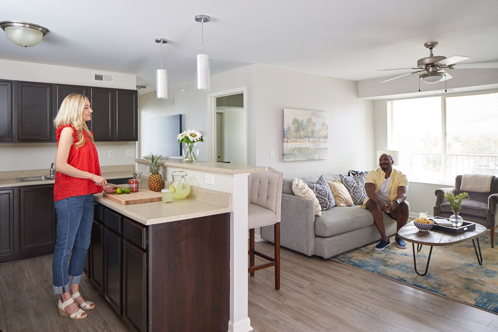 A woman in a red top is standing in a kitchen at Meadowlark Place Apartments, Grimes, IA