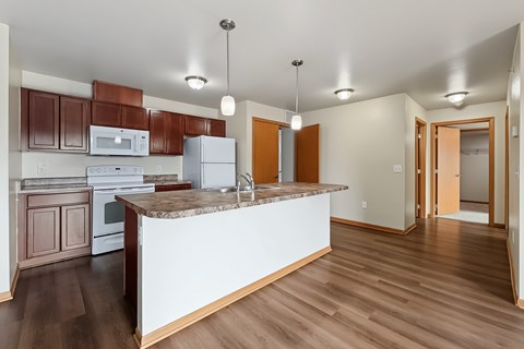 A kitchen with brown cabinets and a white island.