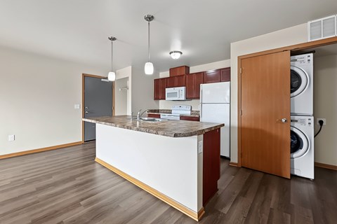 A kitchen with a white counter and brown cabinets.