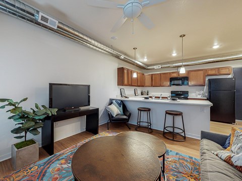 A living room with a brown table and a television on a cabinet.