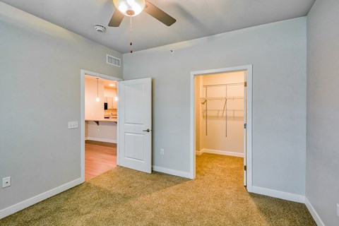 A room with a ceiling fan and two doors.