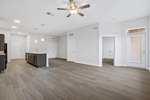 A spacious room with a ceiling fan and lighting fixtures.