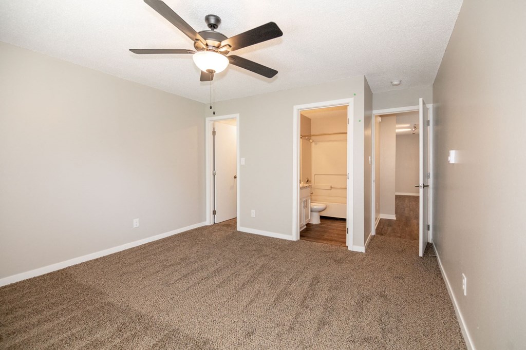 a spacious living room with carpet and a ceiling fan at Rosemont Place Apartments, Iowa, 50320