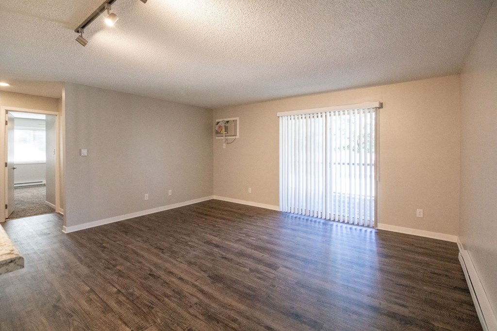 an empty living room with wood flooring and a window at Rosemont Place Apartments, Des Moines, 50320