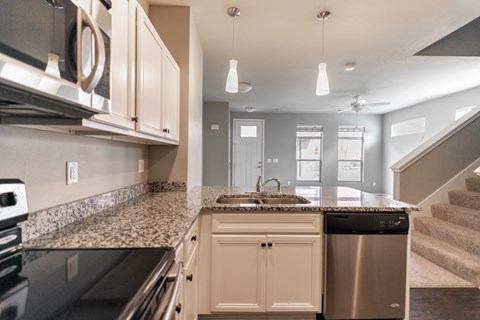 A kitchen with a granite countertop and stainless steel appliances.