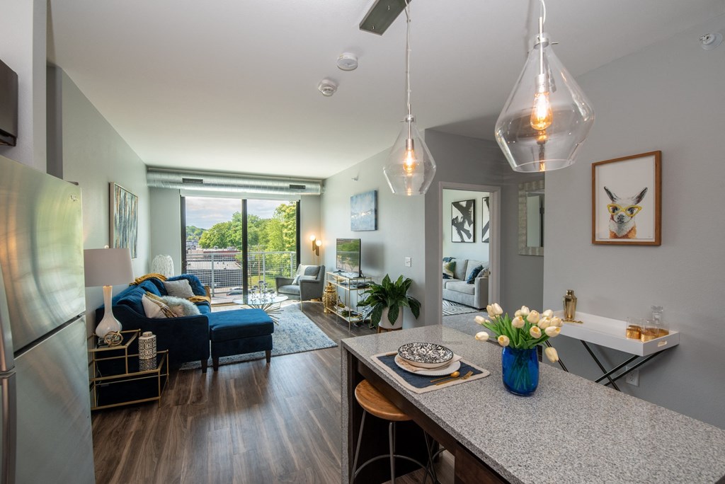 an open living room and dining room with a kitchen counter and a living room at Soll, Des Moines, IA 50312  